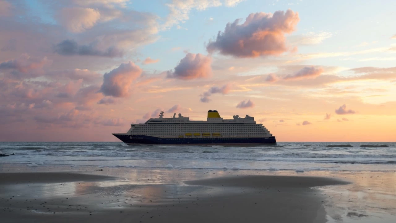 Saga cruise photography — Spirit of Discovery cruise ship at sunset reflected on a wet shoreline